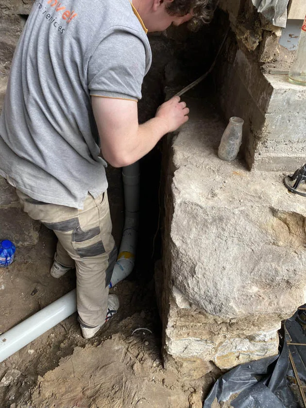 Running a new drain line beside an old sandstone footing